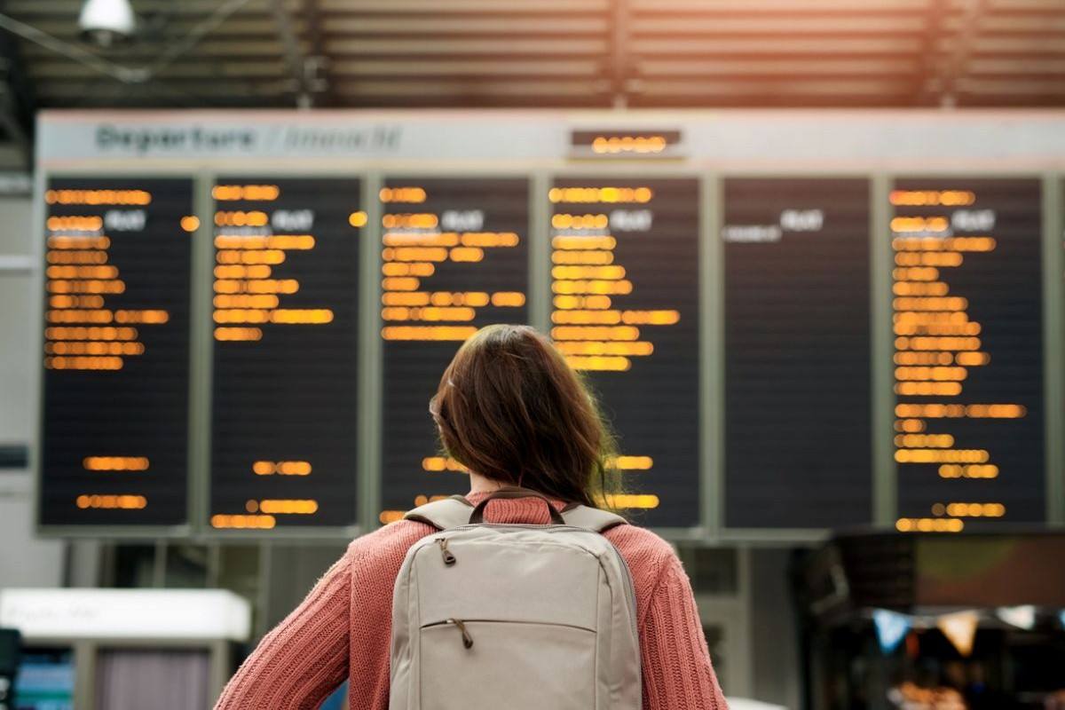 A woman checking an airport departures board