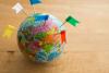 Color flag pins marks on earth globe with wooden table background