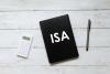 Top view of calculator,pen and notebook written with ISA (individual saving account) on white wooden background