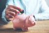 A man putting coins into a piggy bank